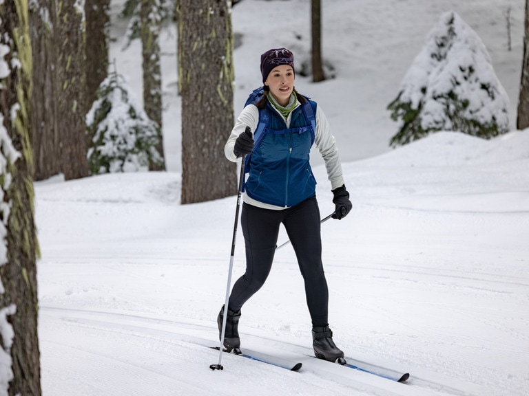 A cross-country skiers wears a hat and gloves for added warmth.