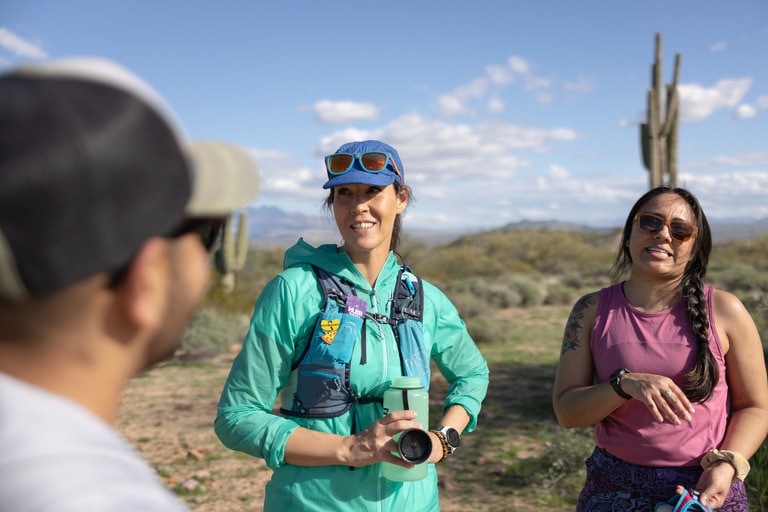 Three people taking a break during a run in the desert