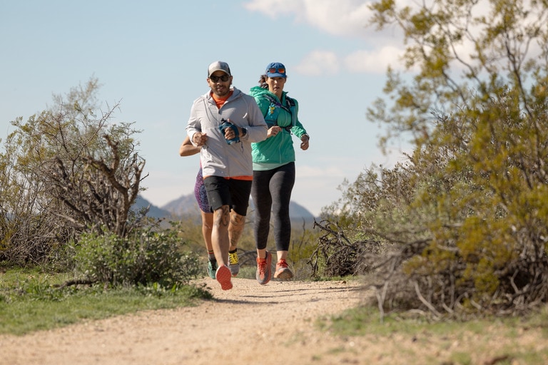 Three people running on a trail