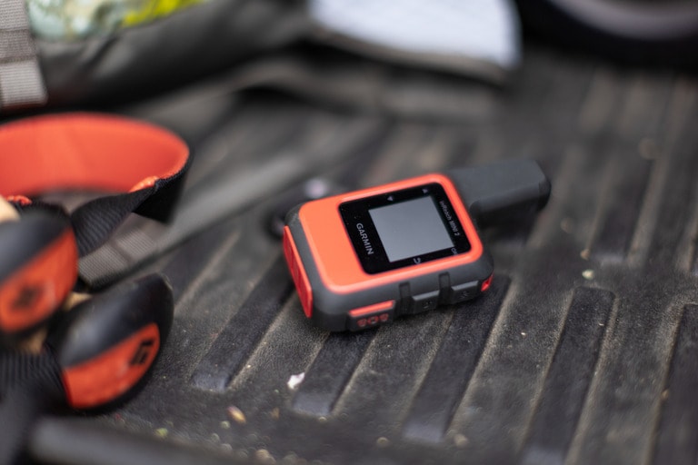 A Garmin mini satellite messenger on a truckbed