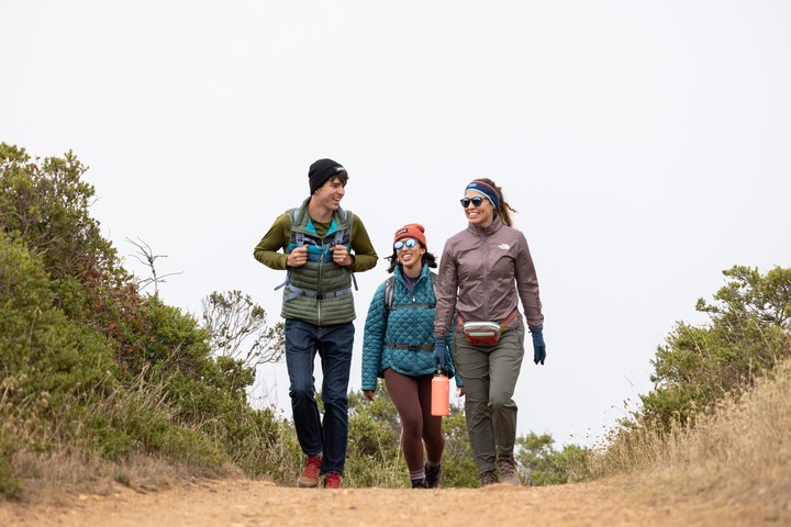 three hikers walking up a dirt trail