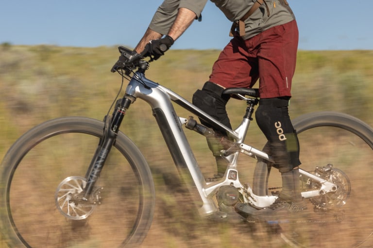 A mountain biker wears knee pads for protection.