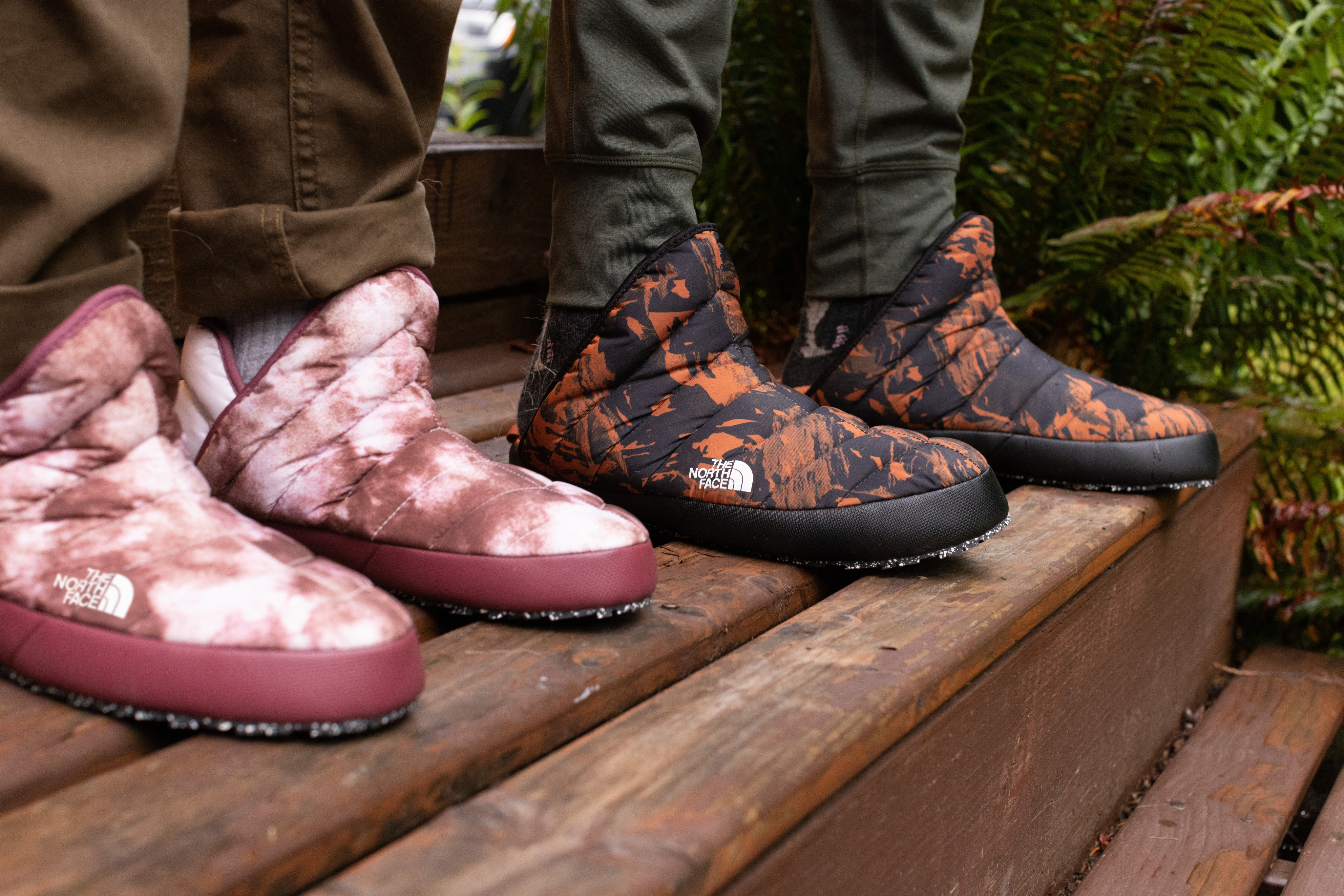 Two people wear insulated booties on a deck