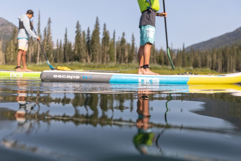 two people paddle on inflatable paddle boards from NRS