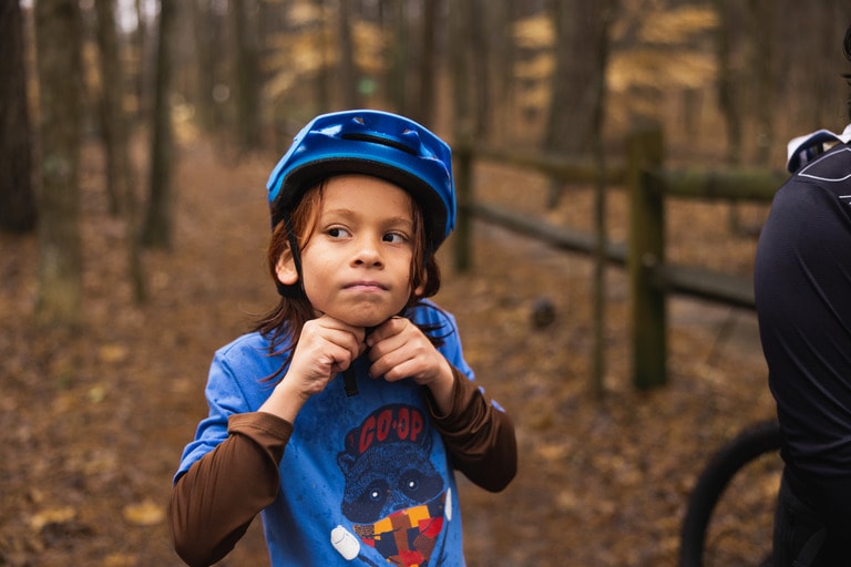 A child puts on a bike helmet