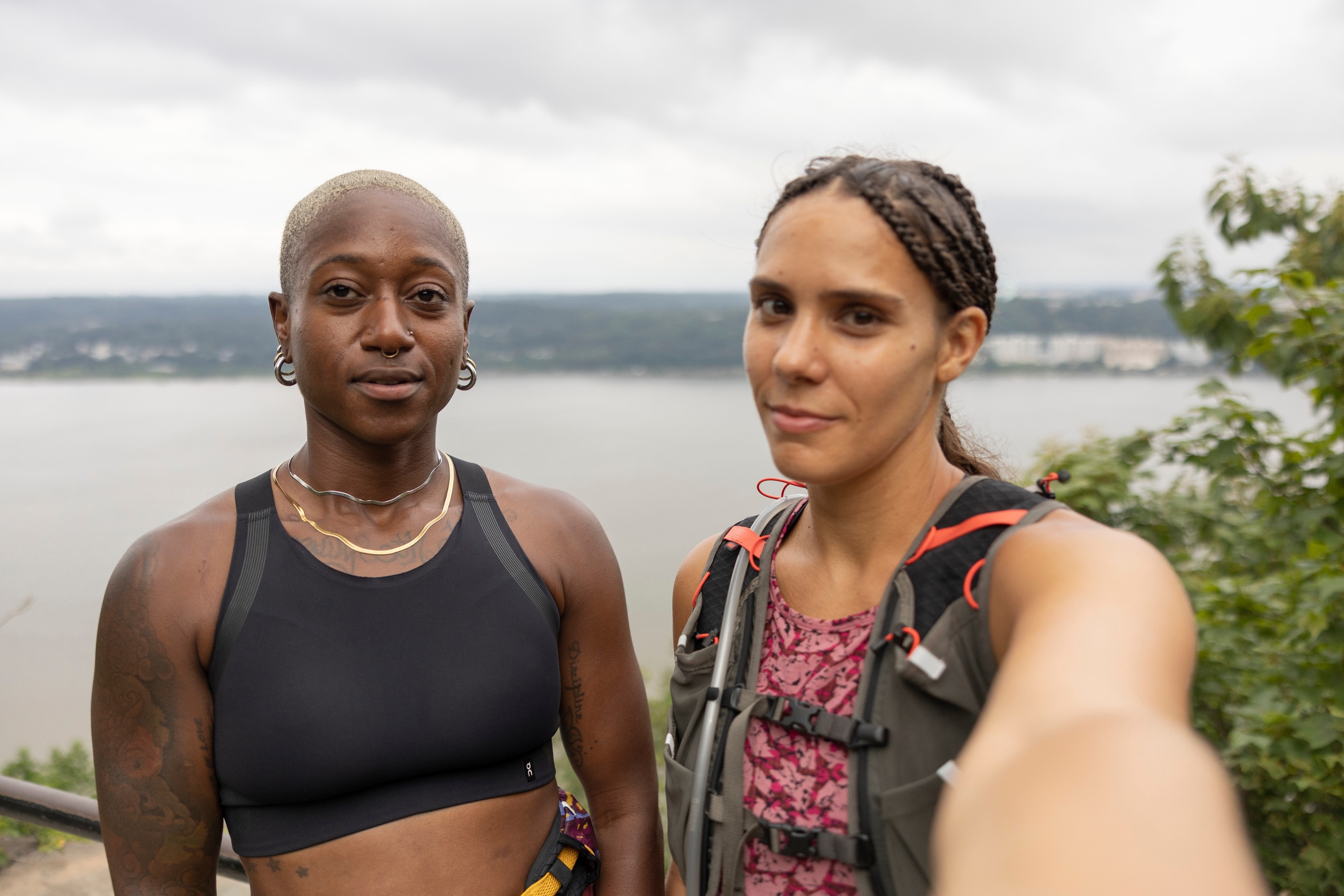 Two runners in sports bras, standing in front of a lake