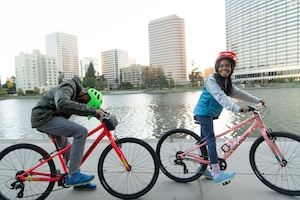 Two youths riding their bikes by the water