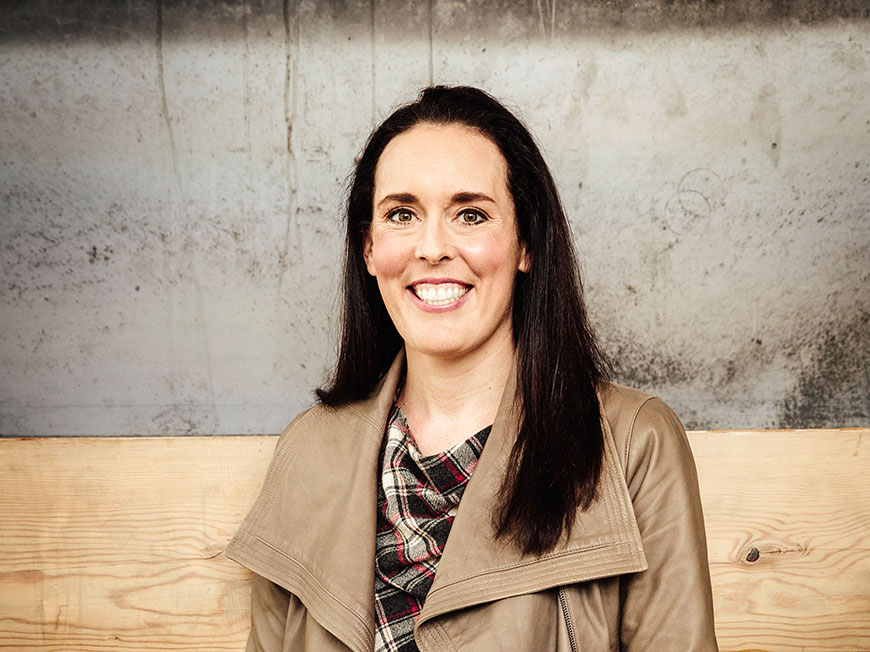 Kate Wendt in front of a wooden wall.