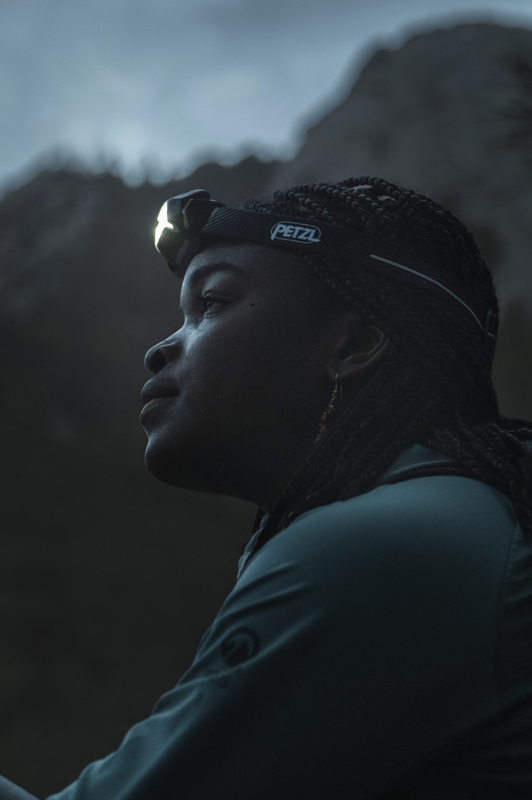 A person wears the Petzl Actik Core Headlamp.