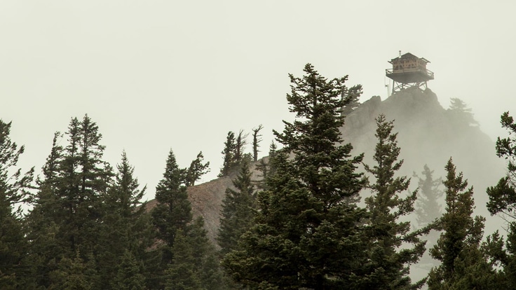 A steep hill leads to an lookout tower in the fog