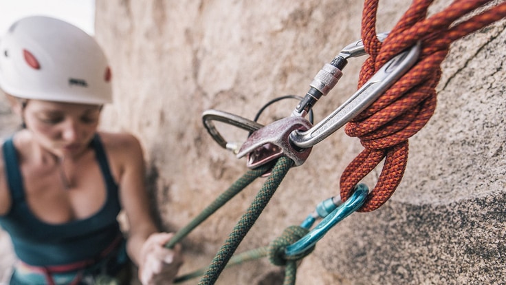 A climber roped into some protection on a rock wall