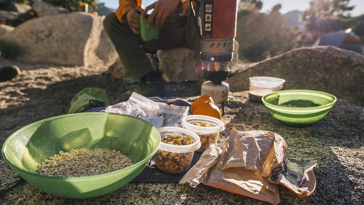 Backpacking meal ingredients with stove in background