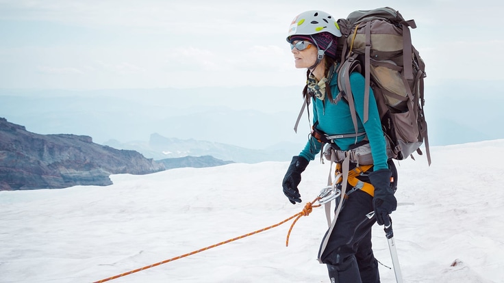 a tired mountaineer roped up and on the mountain