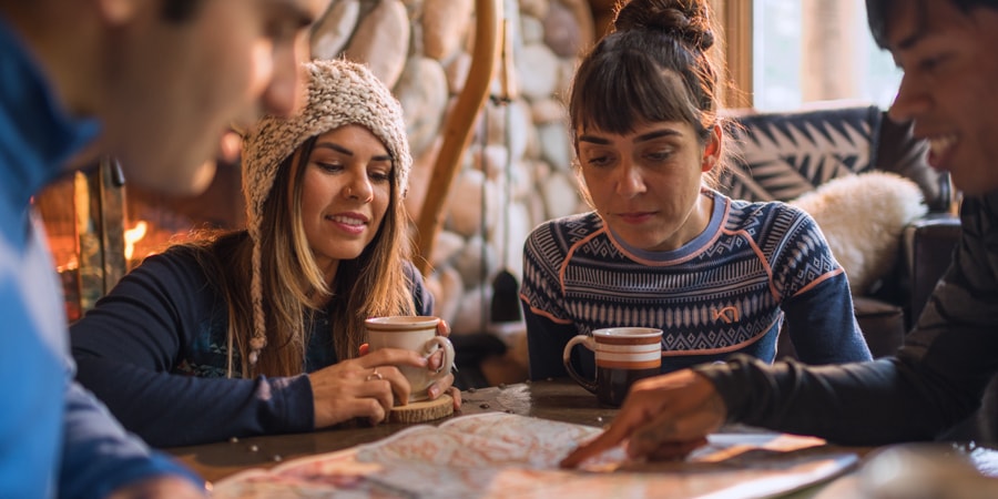 A group of friends looking at a map before heading out for a hike