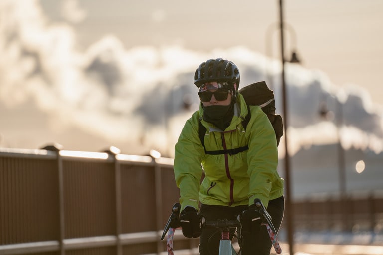 A bike commuter wears a bright yellow cycling jacket