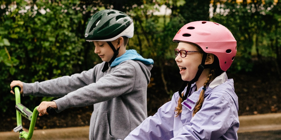 Dos niños en bicicleta con cascos de bicicleta