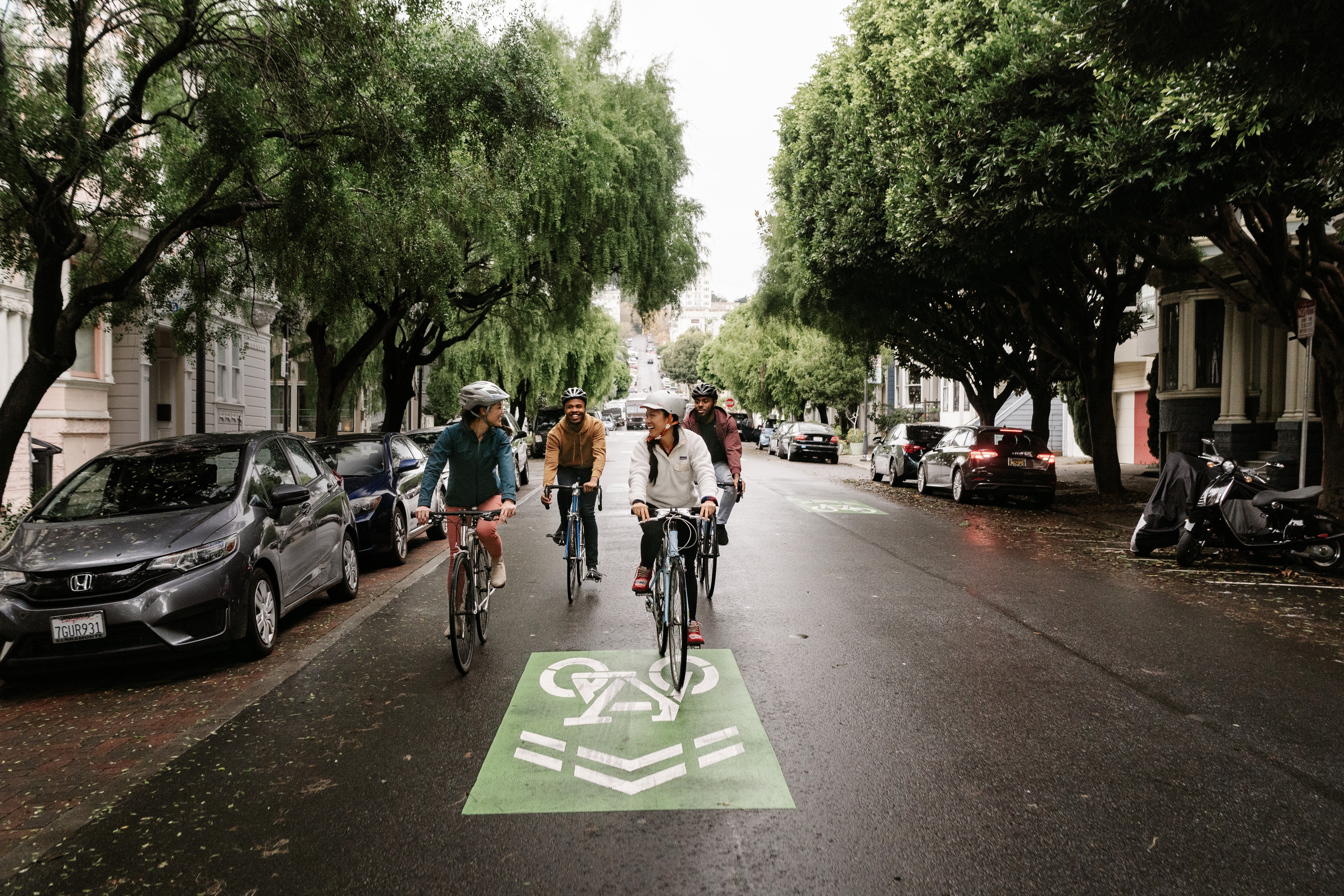two people cycling down a street in San Francisco