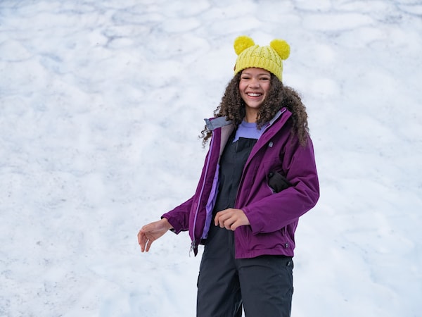 A person stands smiling outside in the snow.