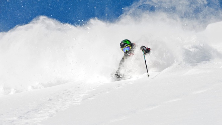 A skier sends up a powder cloud