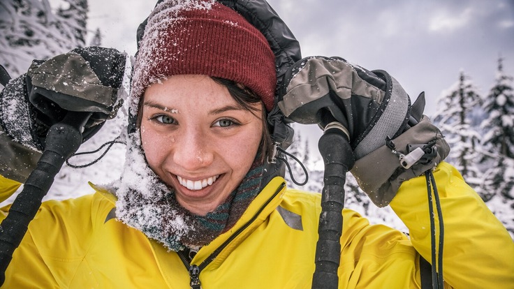 A hiker wears mittens in the snow