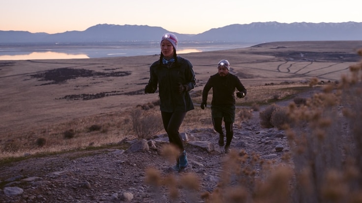 Two runners on a trail at night