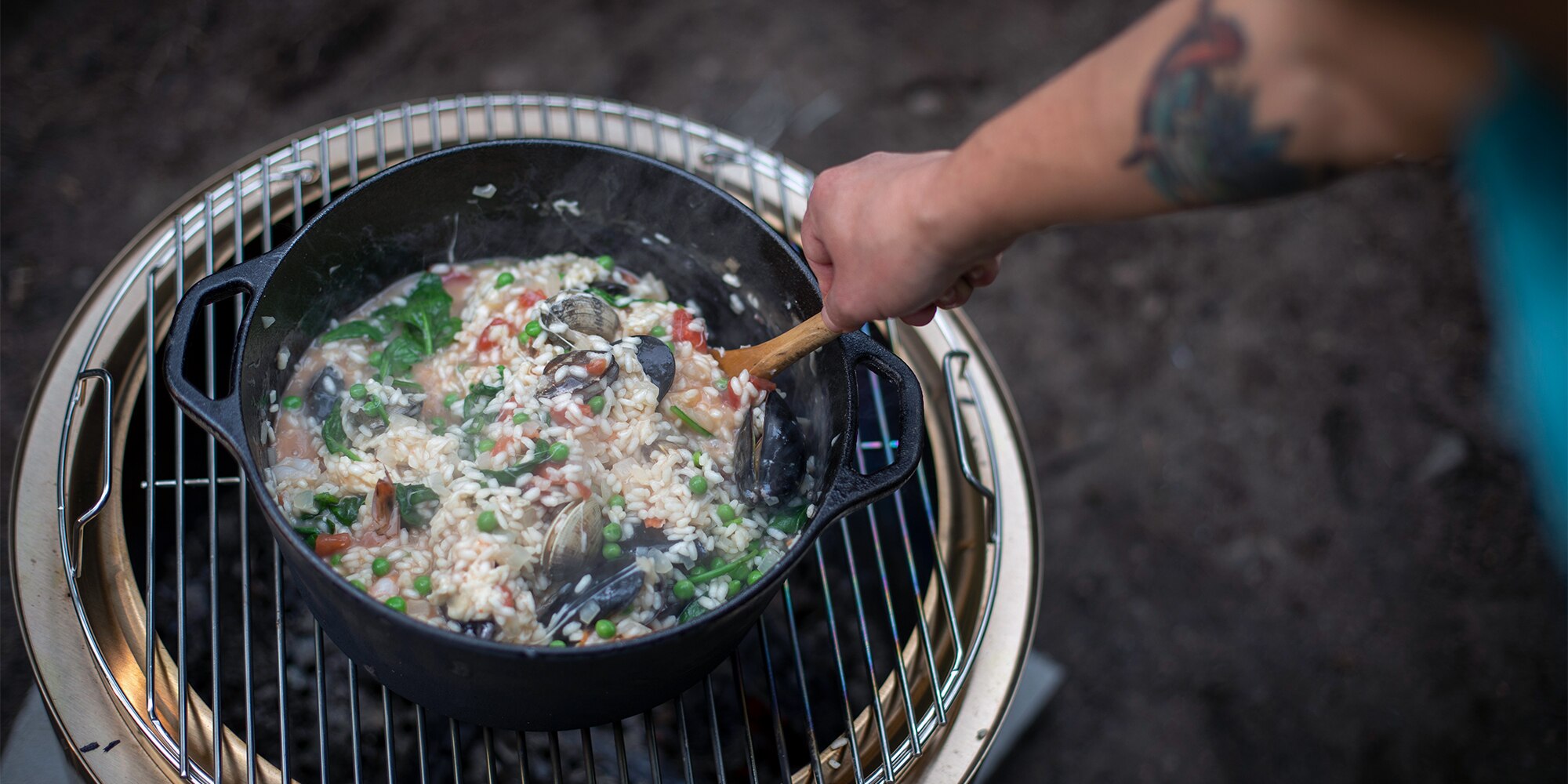 Photo of Maria Hines' hand stirring risotto in a skillet.