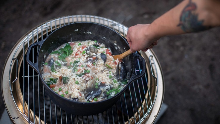 Photo of Maria Hines' hand stirring risotto in a skillet.