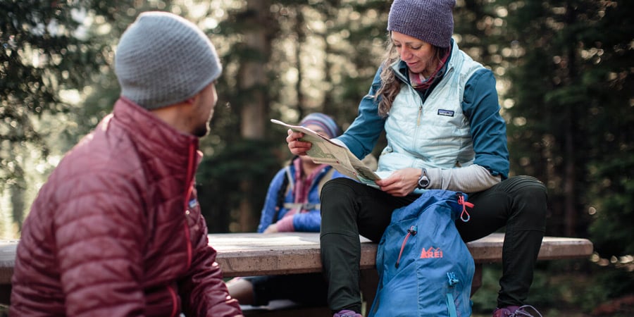 a group of hikers looking at a map to plan out their dayhike
