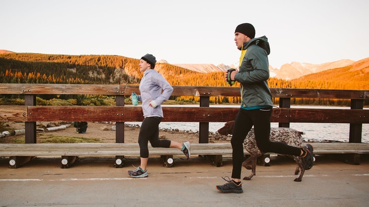 Two runners with mountains in the background