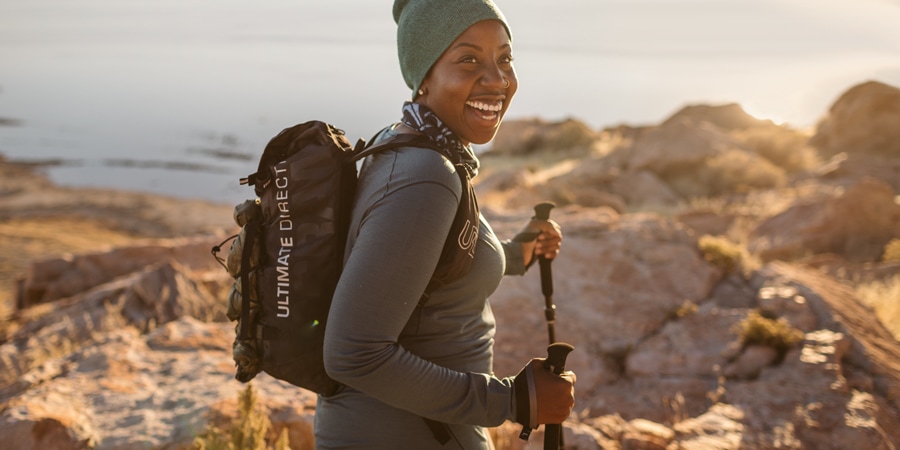 A hiker wearing a backpack and holding trekking poles