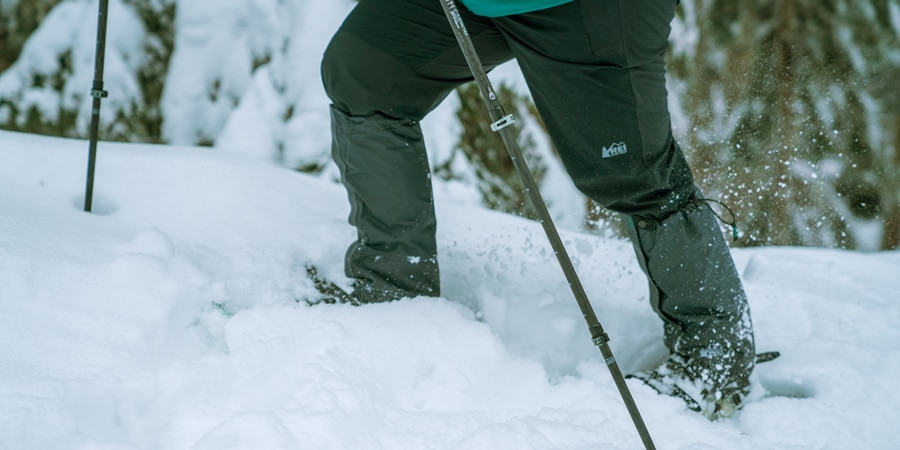 a snowshoer making their way through deep snow with gaiters on