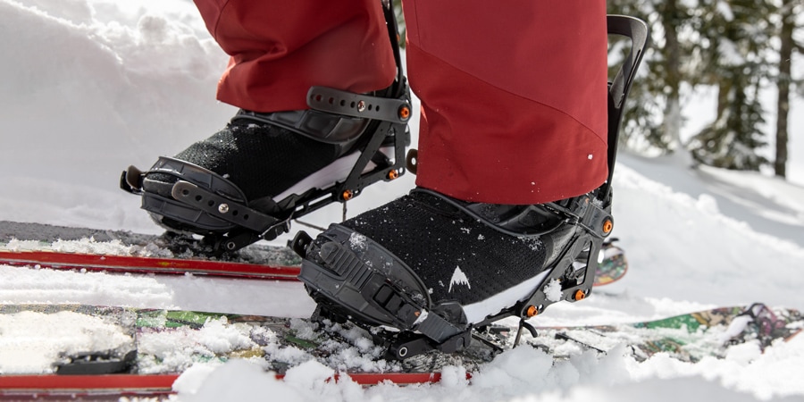 A snowboarder wearing snowboard boots on splitboard skis