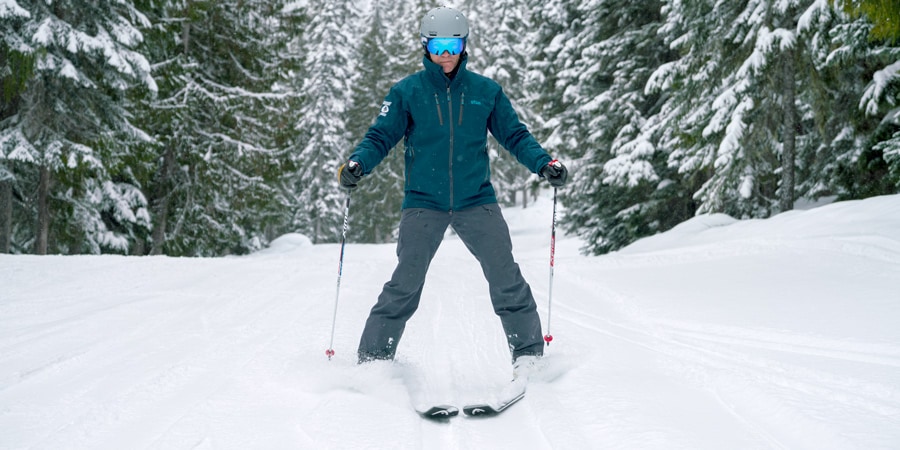 Ein Skifahrer demonstriert, wie er mit seinen Skiern einen Keil (oder ein Dreieck oder eine Pizza) bildet