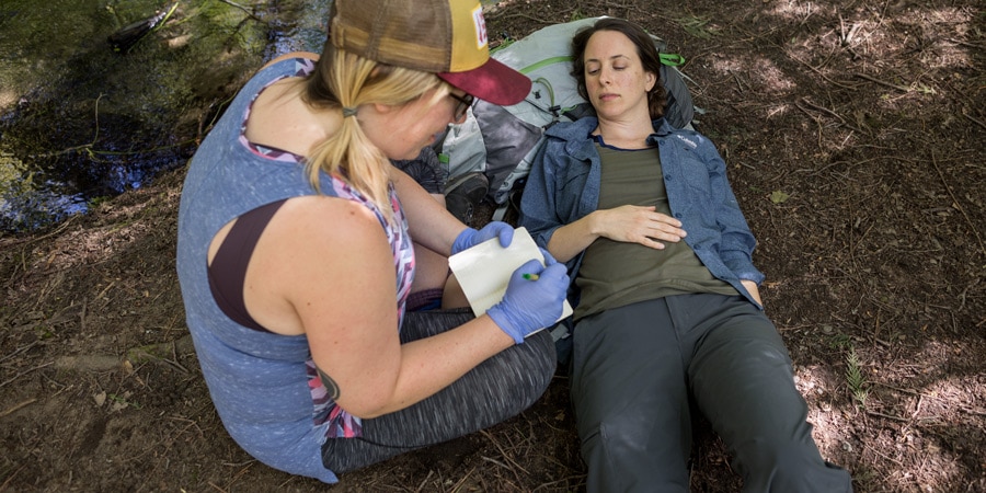 first aid responder taking notes and making a treatment plan for the patient