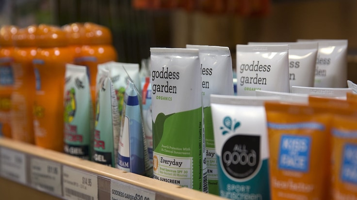 A shelf full of sunscreen products in an REI store