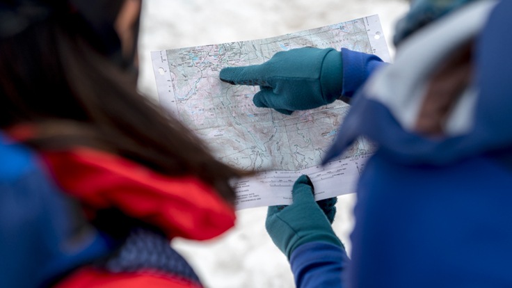 Two mountaineers look at a topographic map