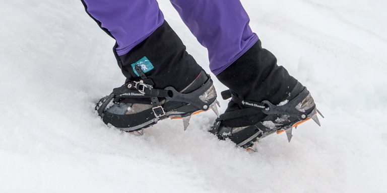 A person wearing crampons frontpoints on a snowy slope