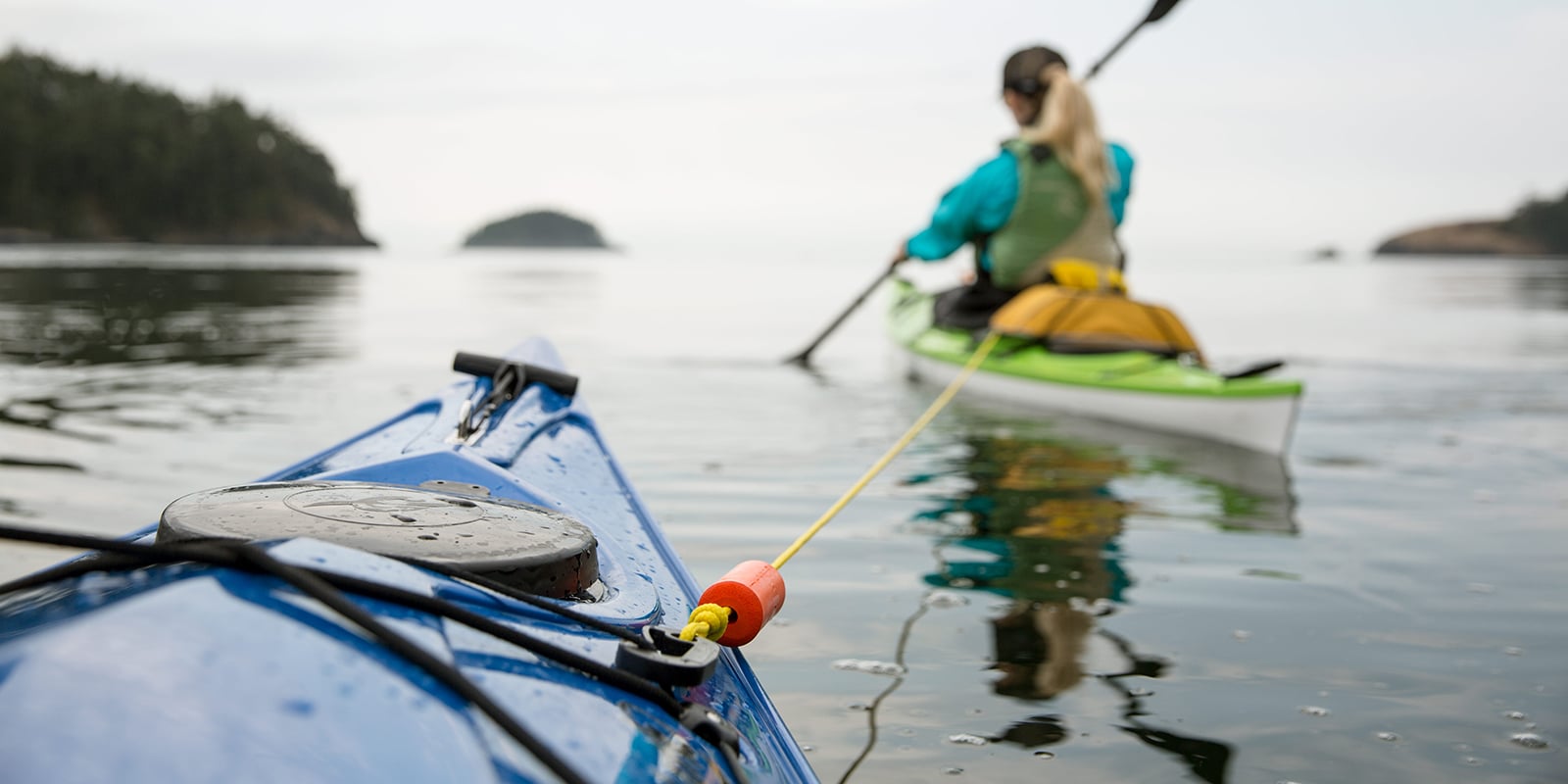 a kayaker being towed by another kayaker