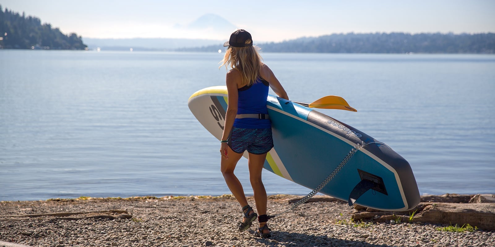a woman holding a paddleboard
