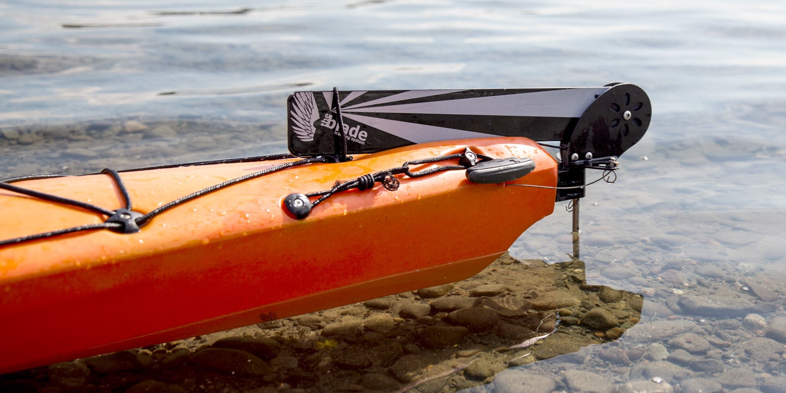 A detail shot of the stern of a kayak sitting in the water with the rudder in the un-deployed position