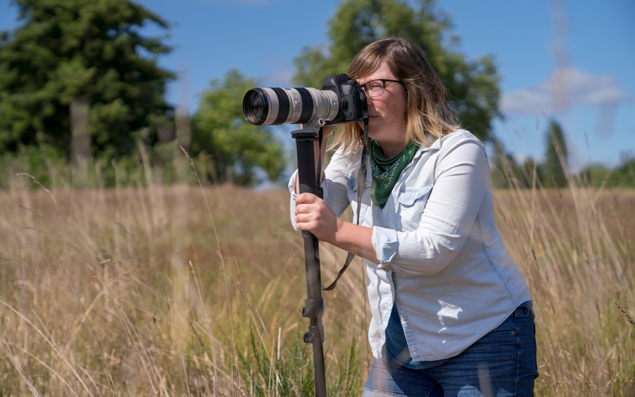 A woman taking a photograph with a zoom lens