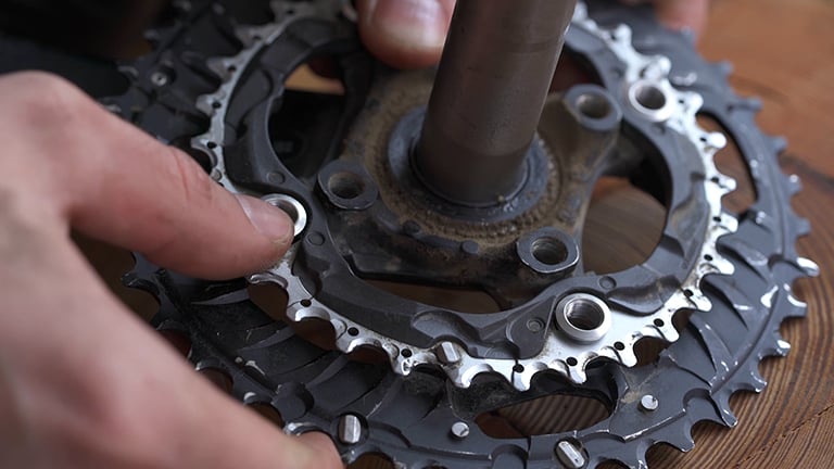 A close up shot of a person's hands holding a bike chainring
