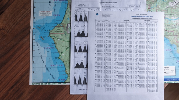 a topo map and tide tables on a tabletop
