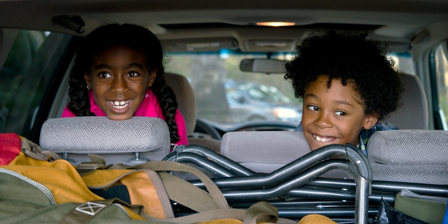 two kids in the back seat of a car, packed for a road trip