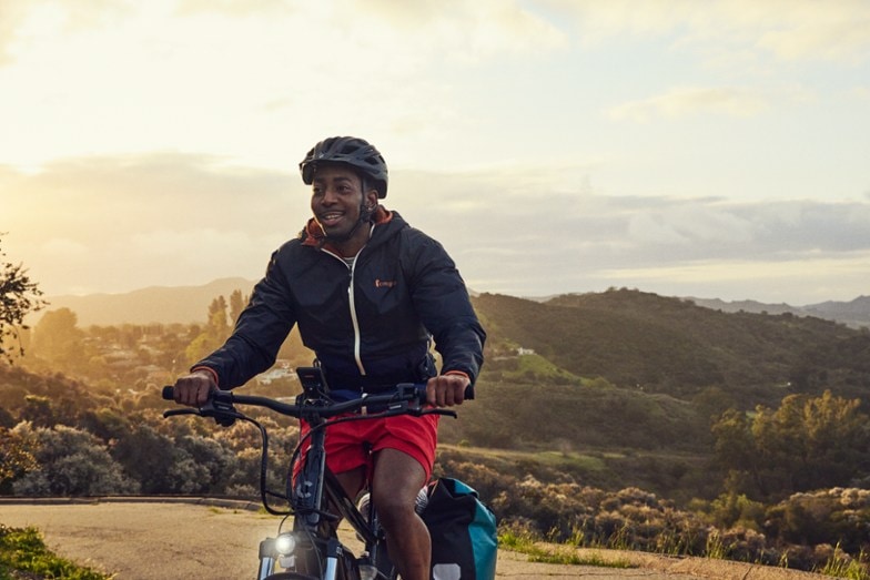 man riding electric bike up a hill