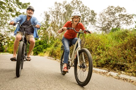 Man and women laughing and riding with class 1 electric bikes