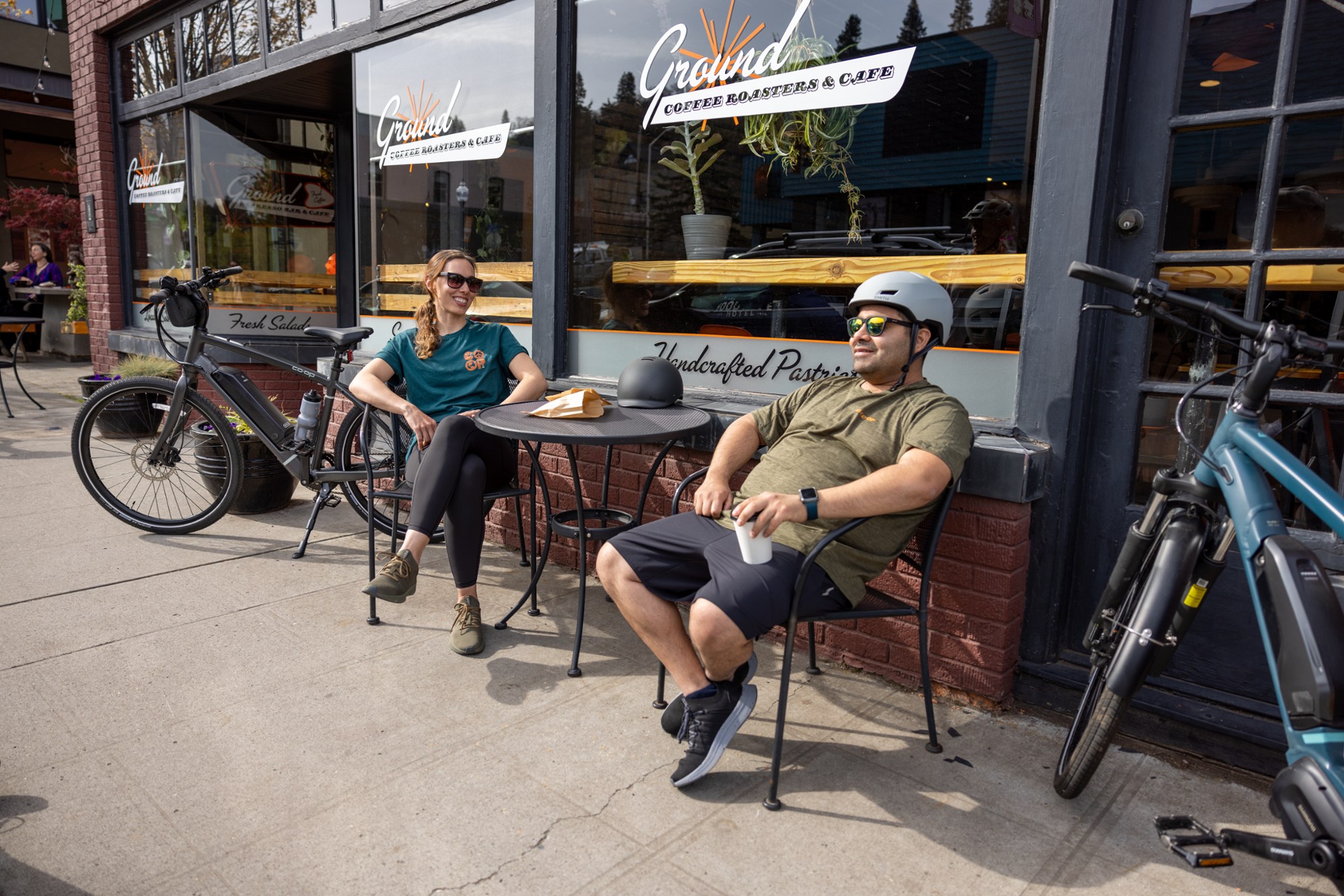 man and woman sitting next to entry-level hybrid bikes
