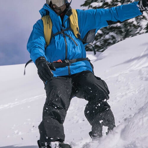 A snowboarder cruises through powder